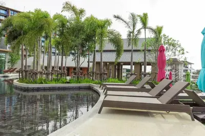 a row of lounge chairs next to a swimming pool at Panora Condo by Villacarte in Surin Beach