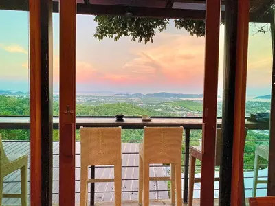 two chairs sitting on a porch with a view at Phuket View Coffee and Resort in Chalong