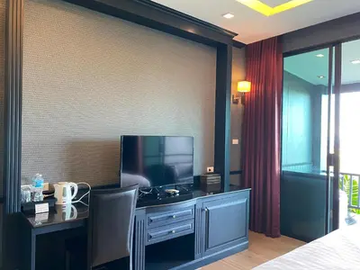 a bedroom with a desk with a television and a bed at Phuket View Coffee and Resort in Chalong