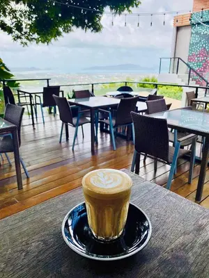 a cup of coffee on a plate on a table at Phuket View Coffee and Resort in Chalong