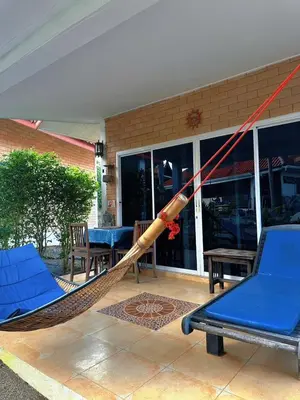 a hammock on a patio with chairs and a table at Sanuk bungalows in Rawai Beach