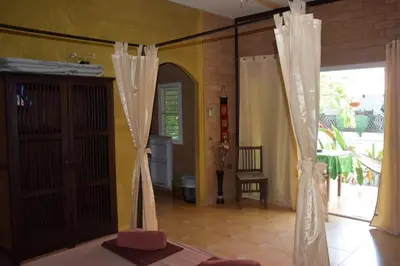 a room with doors and curtains and a room with at Sanuk bungalows in Rawai Beach