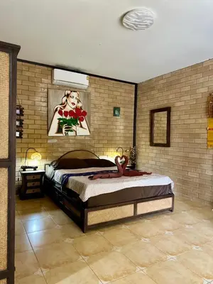 a bedroom with a bed with a picture on the wall at Sanuk bungalows in Rawai Beach