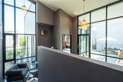 a lobby with large windows and a chair at La Belle Pool Villa Phuket - Home Away from HOME in Bang Tao Beach