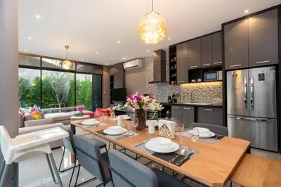 a kitchen and living room with a wooden table and chairs at La Belle Pool Villa Phuket - Home Away from HOME in Bang Tao Beach