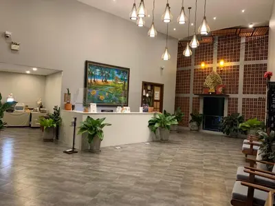 a lobby with potted plants and a counter at Atom Phuket Hotel in Nai Yang Beach