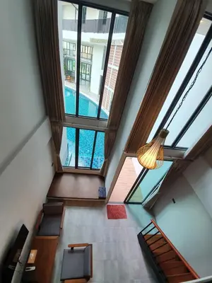 an overhead view of a pool in a building with windows at Atom Phuket Hotel in Nai Yang Beach