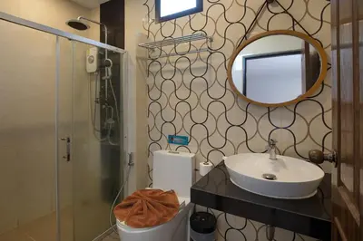 a bathroom with a sink and a mirror and a shower at The Bell Airport Phuket Hotel - SHA Extra Plus in Nai Yang Beach