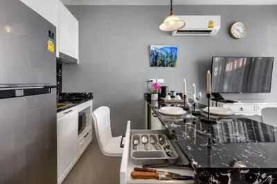 a kitchen with a black counter top in a room at PALMYRAH SURIN, MODERN 1BR with Terrace, 150 meters to Surin Beach in Surin Beach