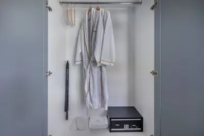 a closet with a door with coats and a knife at PALMYRAH SURIN, MODERN 1BR with Terrace, 150 meters to Surin Beach in Surin Beach