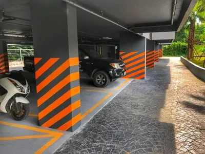 a parking garage with a car parked in it at PALMYRAH SURIN, MODERN 1BR with Terrace, 150 meters to Surin Beach in Surin Beach