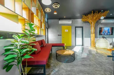 a living room with a red couch and a table at Patong Poshtel in Patong Beach