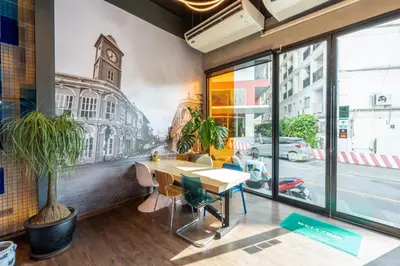 a dining room with a table and a mural of a city at Patong Poshtel in Patong Beach