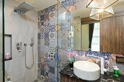 a bathroom with a sink and a shower with a mirror at The Palmyrah Surin by Holy Cow, 1-BR, courtyard or pool view in Surin Beach