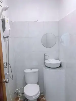 a white bathroom with a toilet and a sink at Baan seefa homestay kohyaoyai in Ko Yao Yai