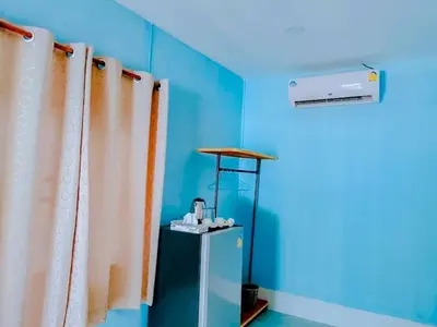 a blue room with curtains and a small refrigerator at Baan seefa homestay kohyaoyai in Ko Yao Yai