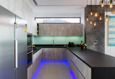 a kitchen with a long counter with blue led lights at Villa Omari 5Bedroom with Pool near Kata Beach in Kata Beach