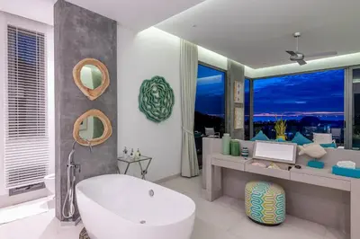 a bathroom with a white tub and a large window at Villa Omari 5Bedroom with Pool near Kata Beach in Kata Beach