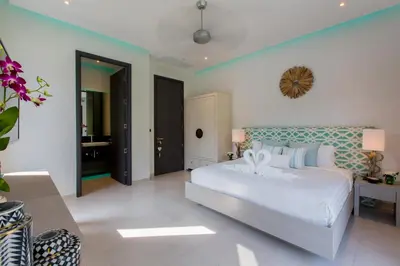 a bedroom with a white bed with a blue headboard at Villa Omari 5Bedroom with Pool near Kata Beach in Kata Beach