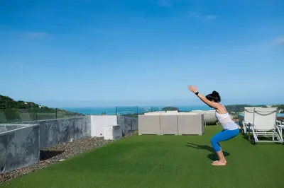 a woman is doing a jump on a roof at Villa Omari 5Bedroom with Pool near Kata Beach in Kata Beach
