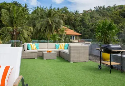 a patio with a couch on a lawn with a grill at Villa Omari 5Bedroom with Pool near Kata Beach in Kata Beach