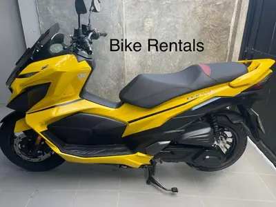 a yellow motorcycle parked next to a building at Bangtao Rooms in Bang Tao Beach