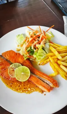a white plate of food with fish and french fries at Bangtao Rooms in Bang Tao Beach