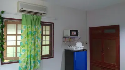 a room with two windows and a heater and a door at Bangtao Rooms in Bang Tao Beach