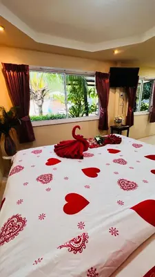 a bed with a red bedspread with hearts on it at At Thara Aonang in Ao Nang Beach