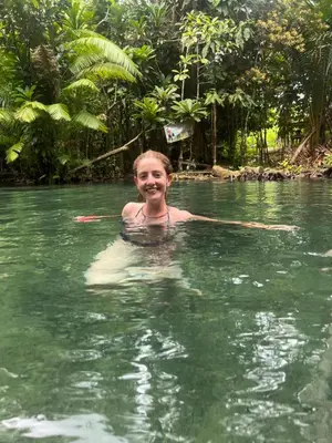 a young boy swimming in a river in the jungle at At Thara Aonang in Ao Nang Beach