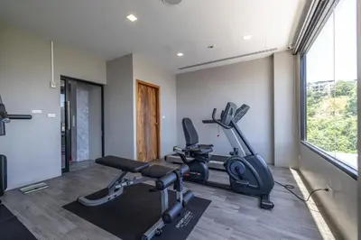 a gym with two exercise bikes and a window at Kana Triple L Hotel Phuket\u666e\u5409\u5c9b\u5361\u5a1c3L\u9152\u5e97 in Patong Beach