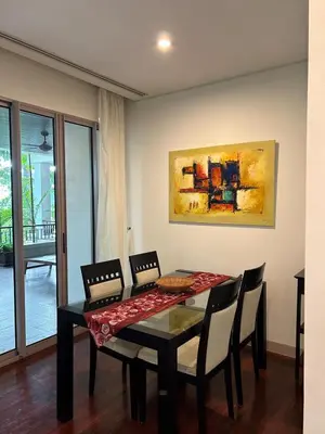 a dining room table with chairs and a painting on the wall at Kata Gardens Luxury Apartment 8A at Kata Noi Beach in Kata Beach