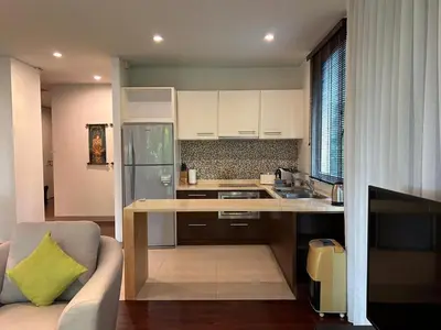 a kitchen with a table and a couch in a room at Kata Gardens Luxury Apartment 8A at Kata Noi Beach in Kata Beach
