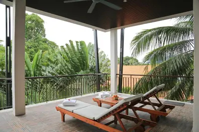 a patio with a chair and a table on a porch at Kata gardens luxury 2bedroom 4B Near Kata Noi Beach in Kata Beach