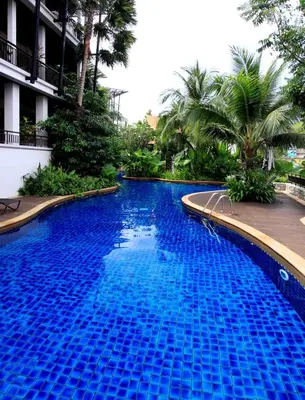 a large blue swimming pool next to a building at Kata gardens luxury 2bedroom 4B Near Kata Noi Beach in Kata Beach