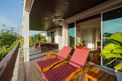 two chairs on the front porch of a house at Ocean views Kata gardens penthouse 6C near Kata Noi Beach in Kata Beach