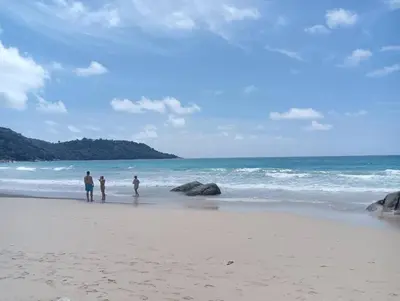 a group of people walking on the beach at Ocean views Kata gardens penthouse 6C near Kata Noi Beach in Kata Beach