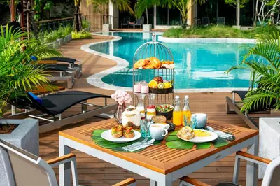 a table with breakfast food on it next to a pool at SKYVIEW Resort Phuket Patong Beach in Patong Beach