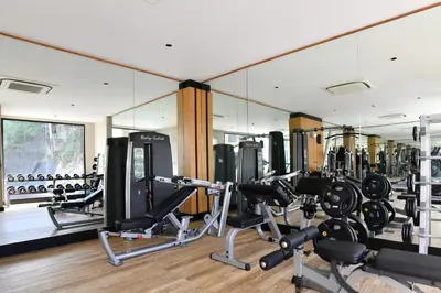 a gym with a large mirror and rows of equipment at SKYVIEW Resort Phuket Patong Beach in Patong Beach