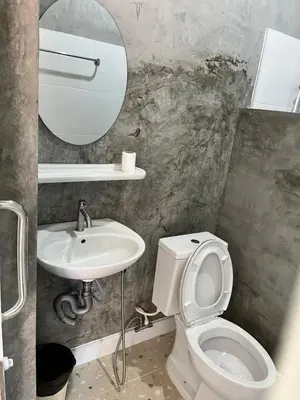 a bathroom with a sink and a toilet and a mirror at Green Mountain Resort Koh Yao in Ko Yao Yai
