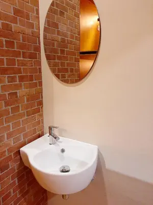 a bathroom with a white sink and a mirror at GN Capsule Hostel Patong in Patong Beach