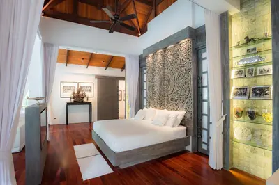 a bedroom with a bed and a ceiling fan at Villa in the Garden, Surin Beach with private spa. in Surin Beach