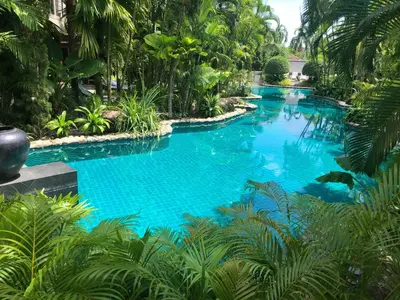 a large blue swimming pool surrounded by trees at Villa in the Garden, Surin Beach with private spa. in Surin Beach