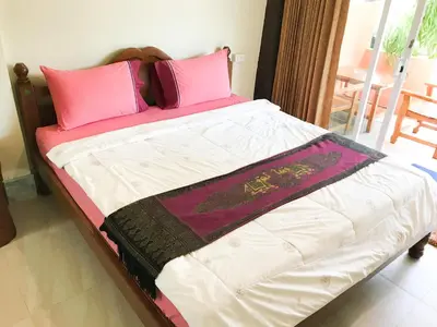 a bed with pink and white sheets and pillows at Discovery House Hotel SHA Plus in Nai Yang Beach