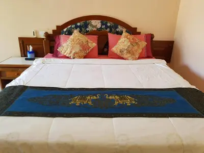 a bedroom with a large bed with red pillows at Discovery House Hotel SHA Plus in Nai Yang Beach