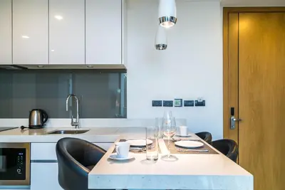 a kitchen with a table and chairs with glasses on it at Oceanstone Resort by Lofty in Bang Tao Beach