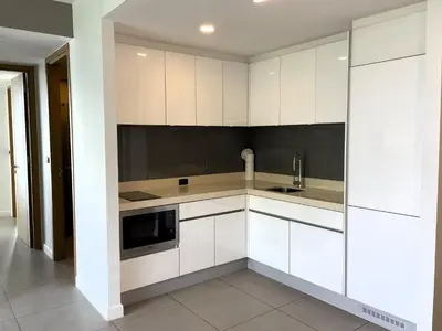 a kitchen with white cabinets and a microwave at Oceanstone Resort by Lofty in Bang Tao Beach