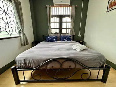 a bedroom with a large bed with blue pillows at Niece Hostel Phuket - Bangtao Beach in Ban Thalat Choeng Thale