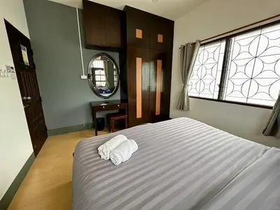 a bedroom with a bed with two towels on it at Niece Hostel Phuket - Bangtao Beach in Ban Thalat Choeng Thale