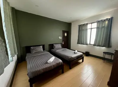 a room with two twin beds and a window at Niece Hostel Phuket - Bangtao Beach in Ban Thalat Choeng Thale